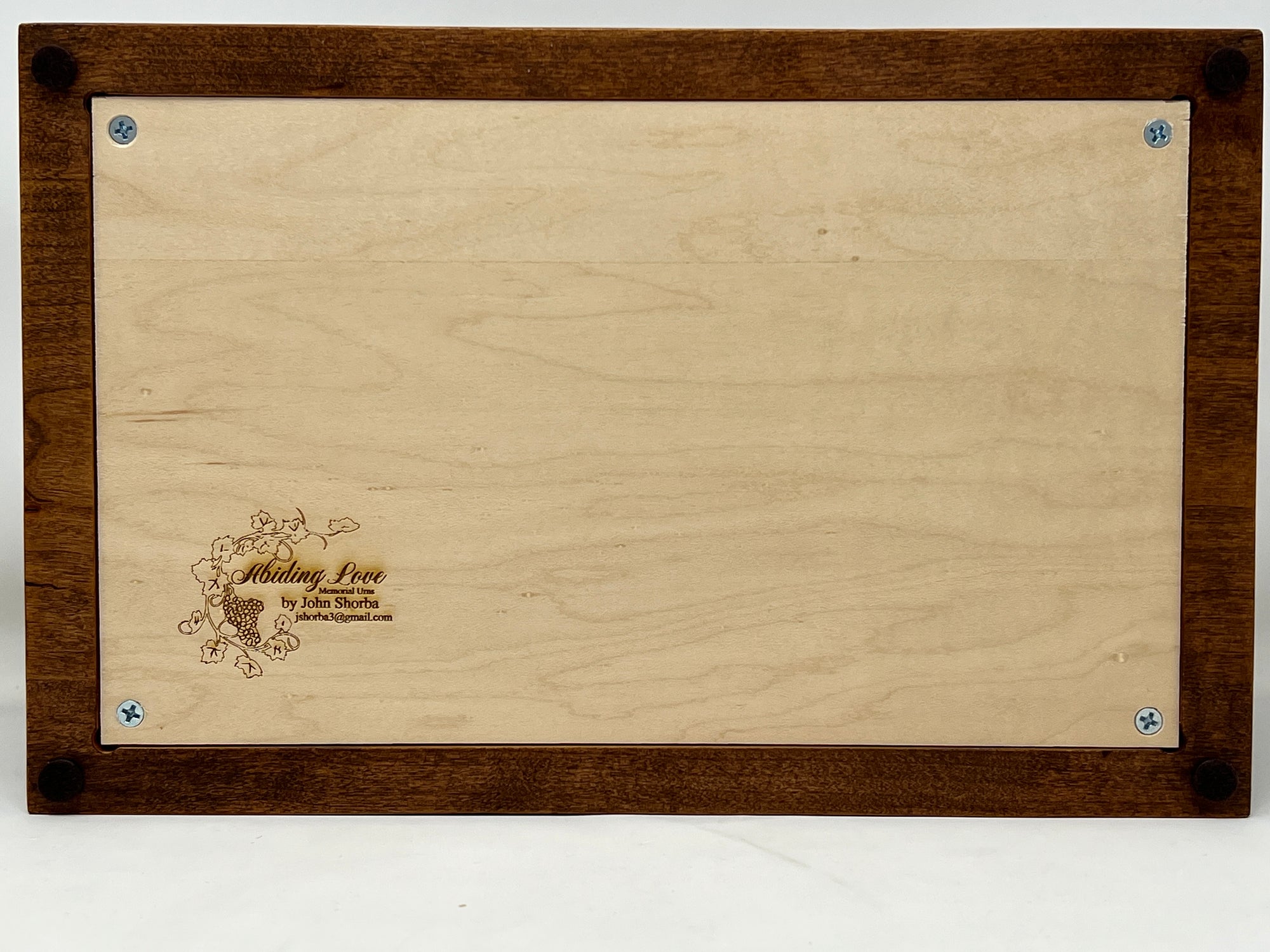The bottom of the urn can be unscrewed with 4 philips head screws. The bottom panel is engraved with Abiding Love memorial urn logo and John Shorba's email jshorba3@gmail.com