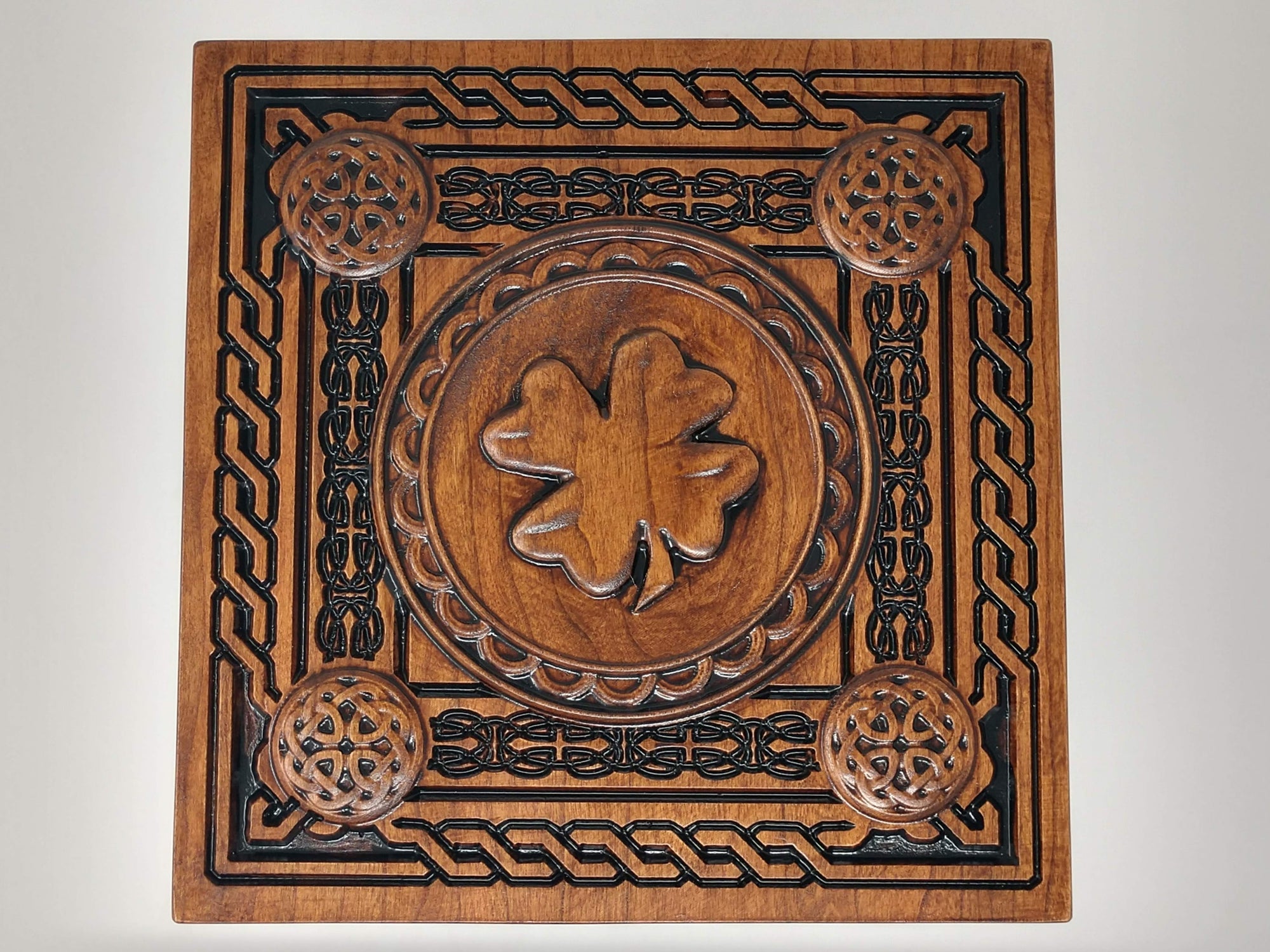 The top of the crematorium urn with the celtic boarders and trinity knot details and shamrock/four-leaf clover in the middle.