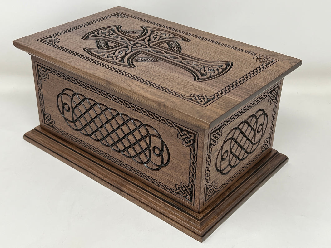 Image shows the top and two sides of the Celtic Cross and Weave Urn. The top has been carved with a woven celtic cross surrounded with a celtic boarder. The sides are carved with  celtic knot carvings and the same celtic boarder as the top. The endges of the top and bottom are nicely finished with moldings. 