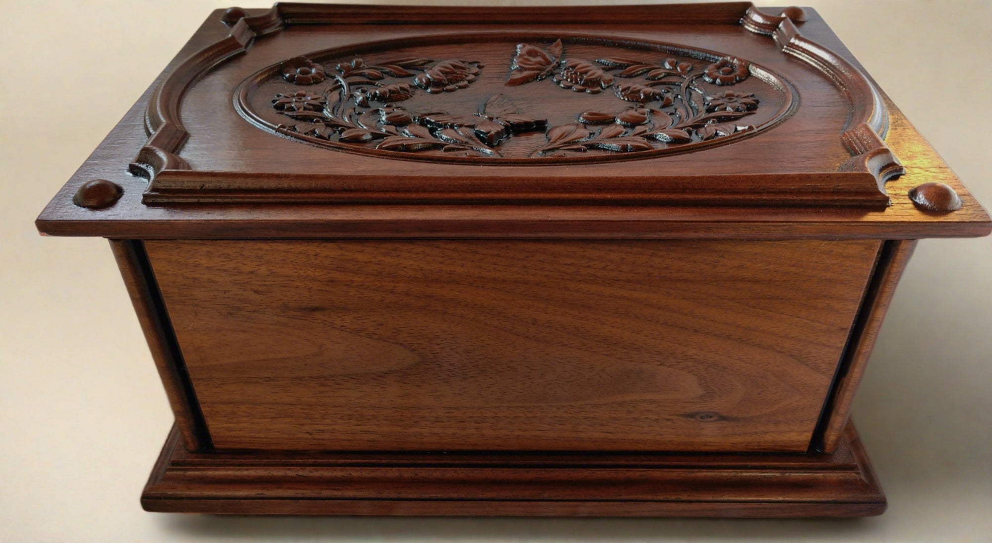 The top has carved images of butterflies and flowers surrounded by an ornate border • Beaded corners with molded edges Human ash urn for sale - elegant and dignified urn for storing cremated remains.